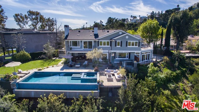 Aerial view of a 2-story house with a pool in the backyard